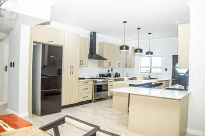 a kitchen with white cabinets and a stove top oven at Batau Villa in Naboomspruit