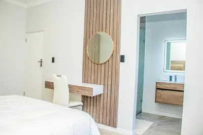 a bedroom with a desk and a mirror at Batau Villa in Naboomspruit