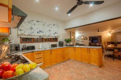 a kitchen with wooden cabinets and a bowl of fruit at Stay at Royal in Marloth Park