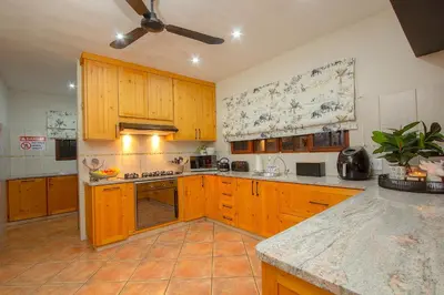 a kitchen with wooden cabinets and a counter top at Stay at Royal in Marloth Park