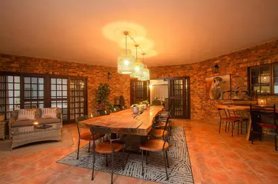 a large dining room with a wooden table and chairs at Stay at Royal in Marloth Park
