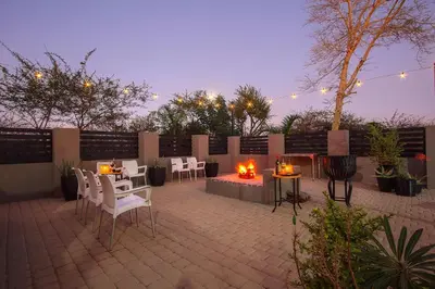 a patio with white chairs and a fire pit at Stay at Royal in Marloth Park