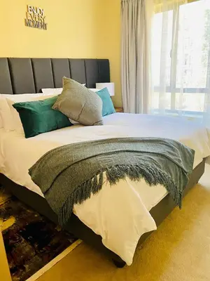 a bedroom with a large bed with a large window at Phoenix Rising Apartment in Midrand