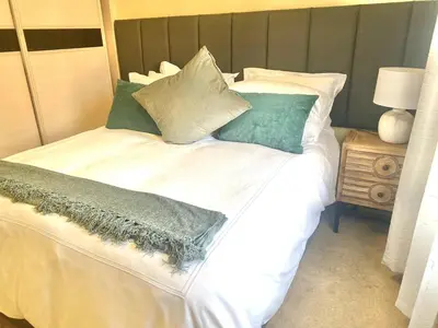 a large white bed with pillows on top of it at Phoenix Rising Apartment in Midrand
