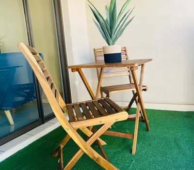 a wooden chair and a table with a potted plant at Phoenix Rising Apartment in Midrand