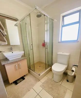 a bathroom with a shower and a toilet and a sink at Phoenix Rising Apartment in Midrand