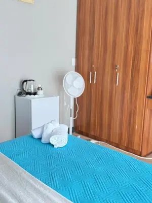 a bedroom with a blue bed with towels on it at Home Away Nest in Witbank