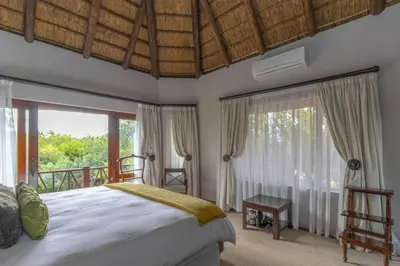 a bedroom with a bed and large windows at Beautiful 4-bedroom, 33 Zebula in Warmbaths