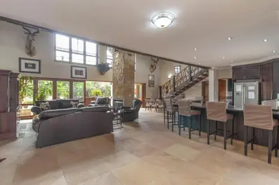 a living room with couches and a bar in a house at Beautiful 4-bedroom, 33 Zebula in Warmbaths