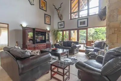 a living room with leather couches and a tv at Beautiful 4-bedroom, 33 Zebula in Warmbaths