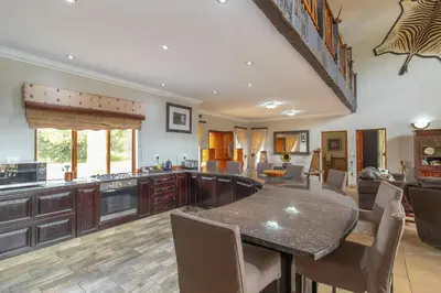 a kitchen with a table and chairs in a room at Beautiful 4-bedroom, 33 Zebula in Warmbaths