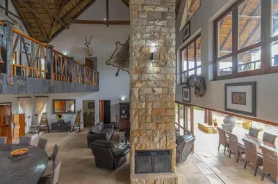 a living room with a stone fireplace in a house at Beautiful 4-bedroom, 33 Zebula in Warmbaths