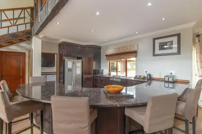 a kitchen with a large island with bar stools at Beautiful 4-bedroom, 33 Zebula in Warmbaths