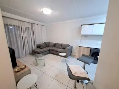 a living room with a couch and a tv at KD Homes in Pretoria