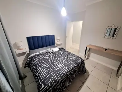 a bedroom with a bed with a blue head board at KD Homes in Pretoria
