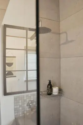 a bathroom with a shower with a mirror and a sink at Stayfit 01 in Polokwane
