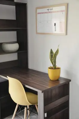 a desk with a potted plant and a yellow chair at Stayfit 01 in Polokwane