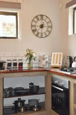 a clock on the wall above a stove in a kitchen at Stayfit 01 in Polokwane