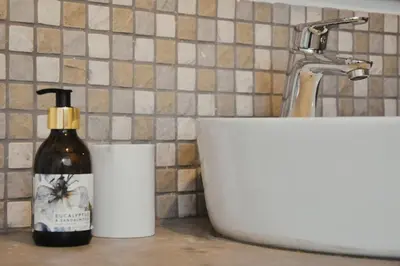 a bottle of soap sitting next to a sink at Stayfit 01 in Polokwane