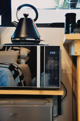 a microwave sitting on a table with a lamp on top at StayFit 02 in Polokwane