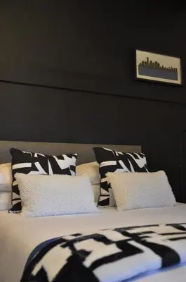 a bed with black and white pillows on it at StayFit 02 in Polokwane