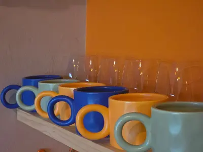 a row of blue and orange cups sitting on a shelf at Stayfit 03 in Polokwane