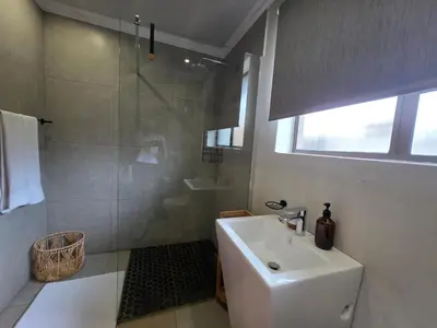 a white bathroom with a sink and a shower at Stayfit 03 in Polokwane