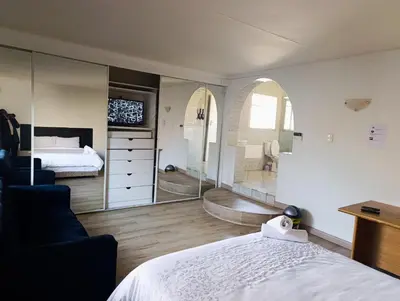 a bedroom with a bed and a large mirror at TRIANGLE STARS Guest House in Kempton Park