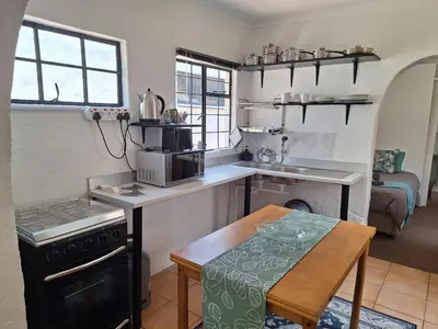 a kitchen with a stove and a table in a room at Midrand-Living Water's Sanctuary in Midrand