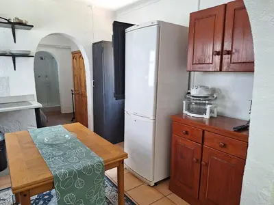 a kitchen with a table and a white refrigerator at Midrand-Living Water's Sanctuary in Midrand