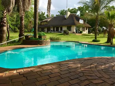 a swimming pool in front of a house at Midrand-Living Water's Sanctuary in Midrand