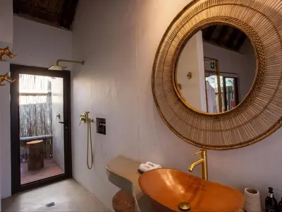 a bathroom with a wooden sink and a mirror at Etnika Manor House in Hoedspruit