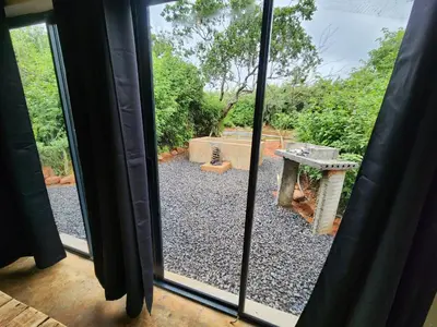 a view of a garden from a window at Hartbeest Bush Stay #26 in Kosmos