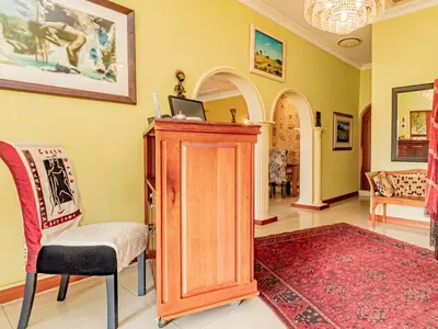 a living room with a chair and a cabinet at Casta Diva Boutique Hotel in Pretoria