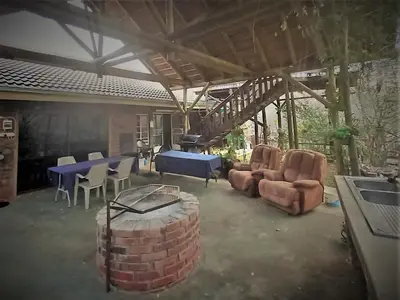 a living room with a table and chairs and a table at Leeupoort Bosvakansie in Leeupoort