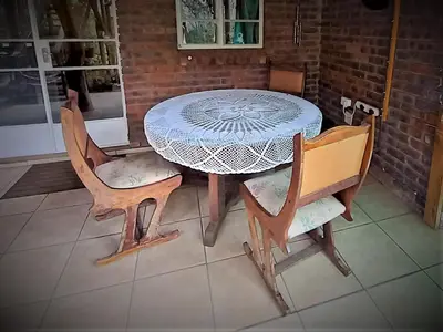 a table with four chairs and a table and a table and chairs at Leeupoort Bosvakansie in Leeupoort