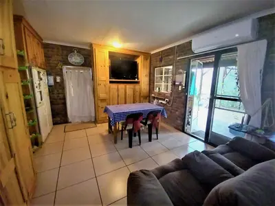 a living room with a table and a couch at Leeupoort Bosvakansie in Leeupoort