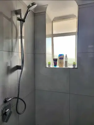 a shower in a bathroom with a window at Neat, instaworthy, self-checkin flat in Pretoria in Pretoria