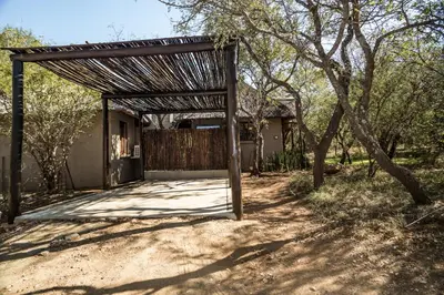 an open gate to a house with a fence at Hoedspruit Raptors Lodge N16 in Hoedspruit