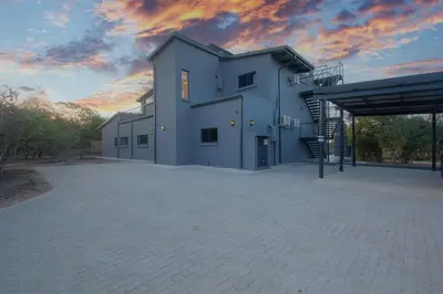 a large white building with a sky in the background at Giraffe Oasis - Kruger Luxury Family Villa in Marloth Park