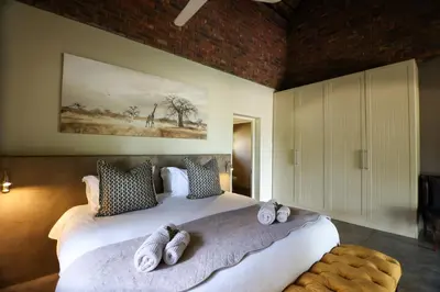 a bedroom with a large bed with towels on it at Senalala Safari Lodge in Klaserie Private Nature Reserve