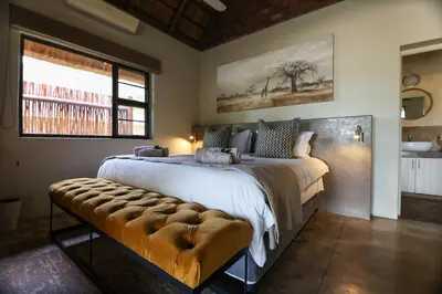a bedroom with a large bed and a window at Senalala Safari Lodge in Klaserie Private Nature Reserve