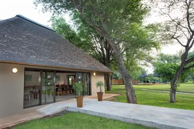 a house with a patio and a tree at Senalala Safari Lodge in Klaserie Private Nature Reserve