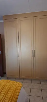 a bedroom with wooden cabinets and a bed in it at 9 on Deimos Ave in Polokwane