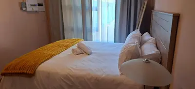 a bed with two pillows and a lamp in a room at 9 on Deimos Ave in Polokwane
