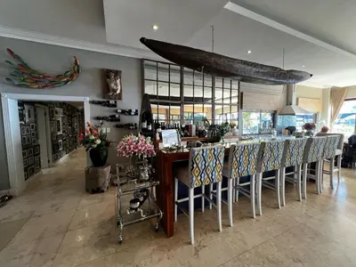 a dining room with a bar with chairs and a boat on the ceiling at Pecanwood Exclusive Luxury Villa Hartbeesport Dam in Hartbeespoort