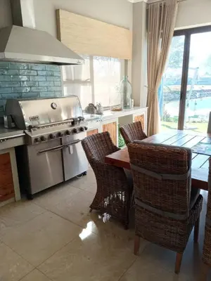 a kitchen with a stove and a table with chairs at Pecanwood Exclusive Luxury Villa Hartbeesport Dam in Hartbeespoort