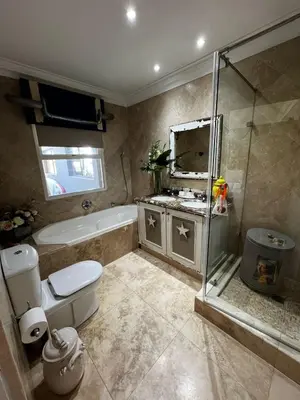 a bathroom with a shower and a toilet and a sink at Pecanwood Exclusive Luxury Villa Hartbeesport Dam in Hartbeespoort