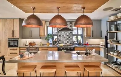 a large kitchen with wooden cabinets and a large island at Pecanwood Exclusive Luxury Villa Hartbeesport Dam in Hartbeespoort