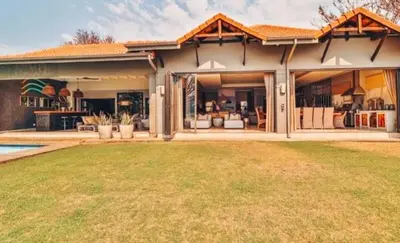 a home with a large patio and a yard at Pecanwood Exclusive Luxury Villa Hartbeesport Dam in Hartbeespoort